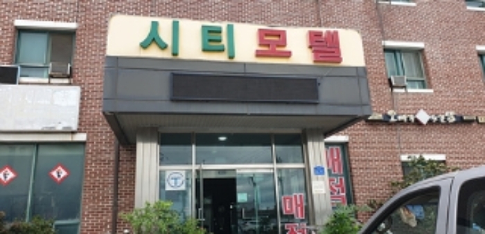 2번 부동산 건물 출입구에 표시되어 있는 시티모텔 상호 모습
