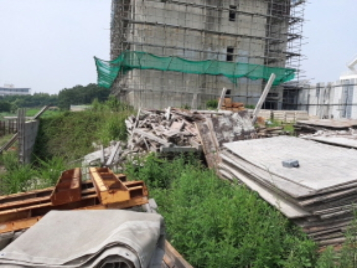 목록2 전경(공사중인 건물일부가 본건 대지에 들어와 있고,나대지엔 건축자재들이 흩어져 있음)