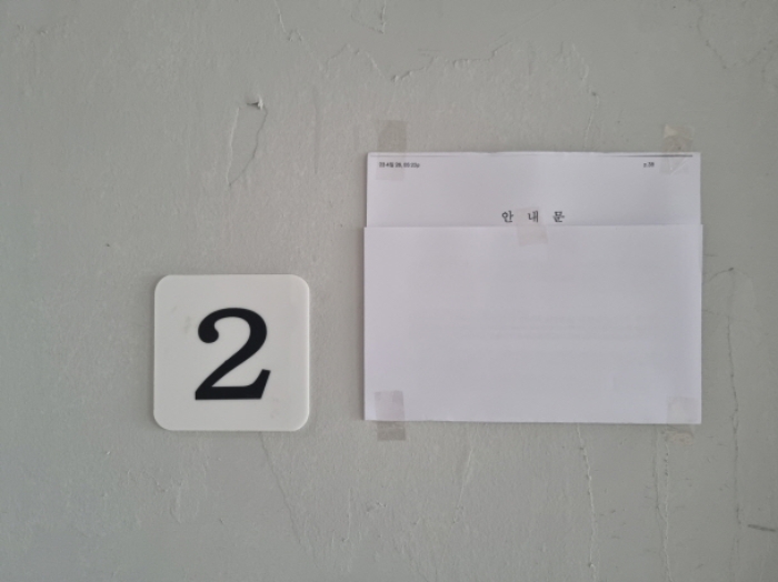 2층 주택 1층 2호실 출입문에 안내문 부착한 사진
