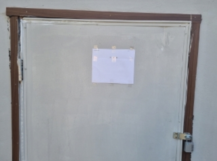 새하늘교회와 2층 주택 사이 건축물 출입문에 안내문 부착한 사진