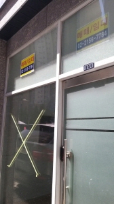 101호 출입문(출입문 위쪽에 매매/임대라고 쓴 글이 붙어 있음)