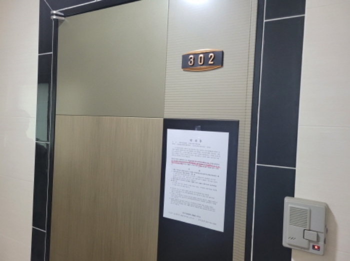302호 현관문에 안내문 부착함.