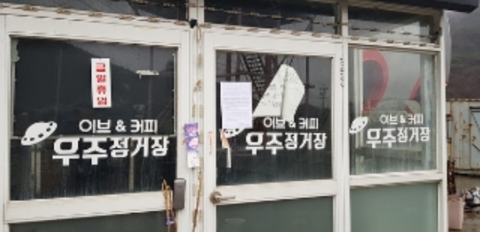 2번 부동산(우주선 모양 2층음식점)의 출입문에 경매안내문을 부착한 모습