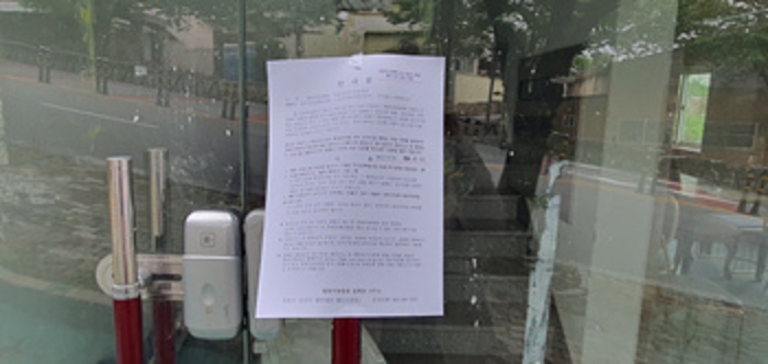 1층왼쪽 출입문에 부동산경매 사건에 대한 안내문 부착(5/7)