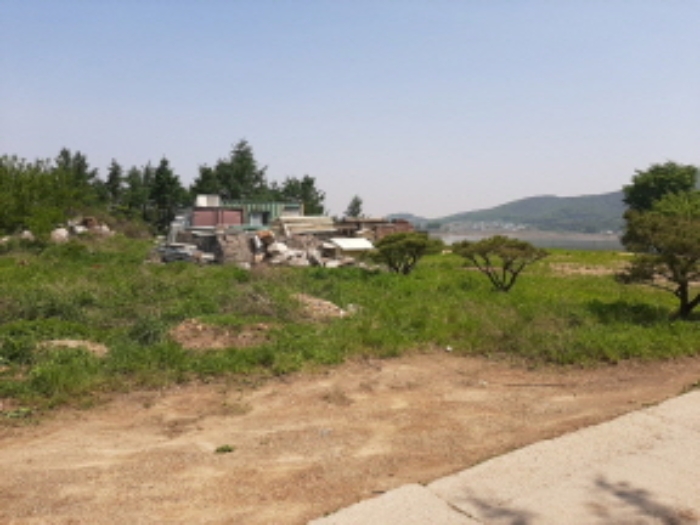 목록2 전경(평탄작업을 한 나대지-끝쪽 경계부근에 제시외 컨테이너,정원석 무더기,앞쪽에 정원수)