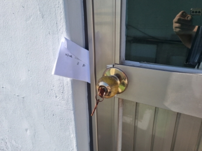 본건 1항 중앙에 위치한 제시외 2층 건물의 출입문 (임차인권리신고 안내장을 남겨둠)