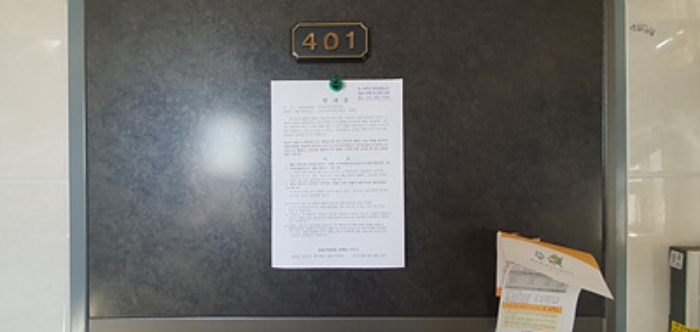 401호의 출입문에 부동산경매 사건에 대한 안내문 부착