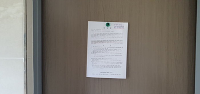 1층계단실 출입문에 부동산경매 사건에 대한 안내문 부착