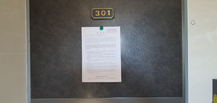 301호의 출입문에 부동산경매 사건에 대한 안내문 부착