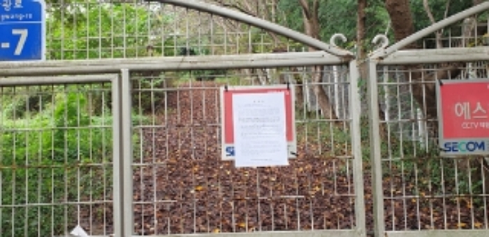 2번 부동산 지상 출입문 안내문 부착 모습