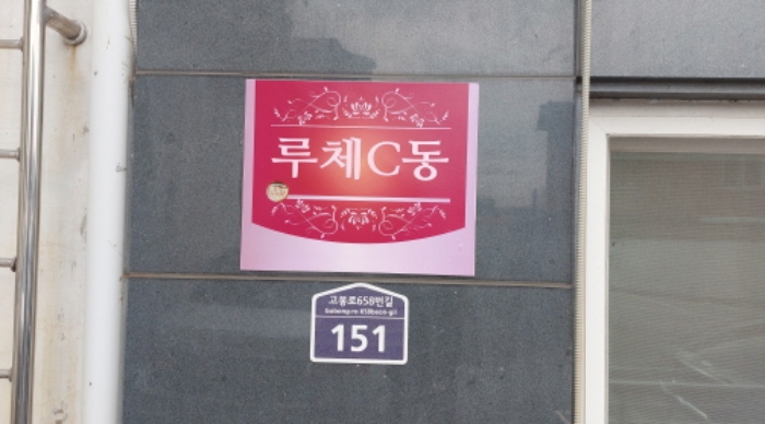위 건물 외벽에 부착된 도로명주소(고봉로658번길 151)와 외벽 전경(루체 C동 표시가 있음)
