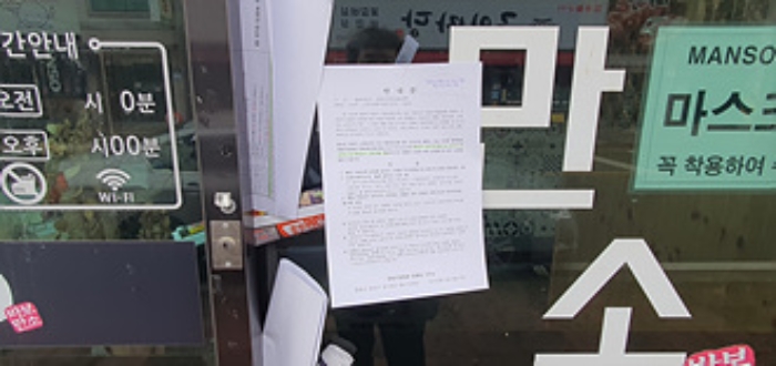 오른쪽 건물 출입문에 부동산경매 사건에 대한 안내문 부착