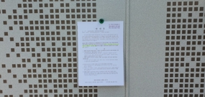 뒤쪽 출입문에 부동산경매 사건에 대한 안내문 게시