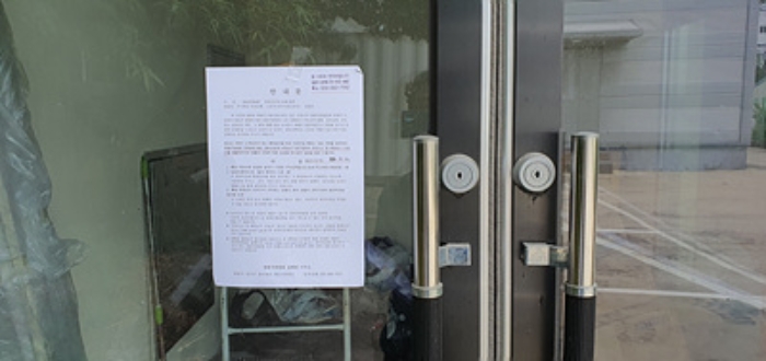 부속건물-출입문에 부동산경매 사건에 대한 안내문 게시(7/23)