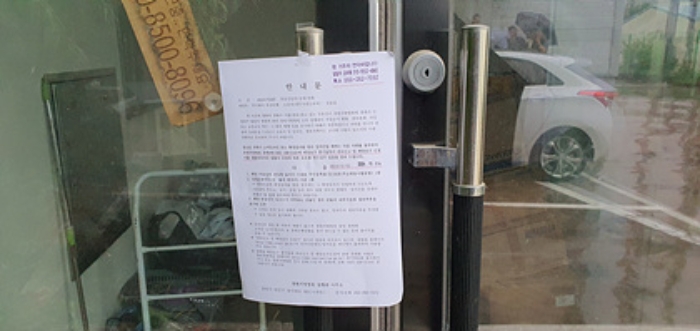 부속건물-출입문에 부동산경매 사건에 대한 안내문 게시(7/16)