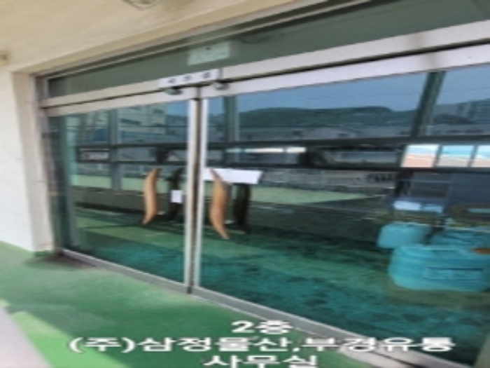 2층 사무실 유리문현관에는 (주)삼정물산, 부경유통 상호가 적혀있음