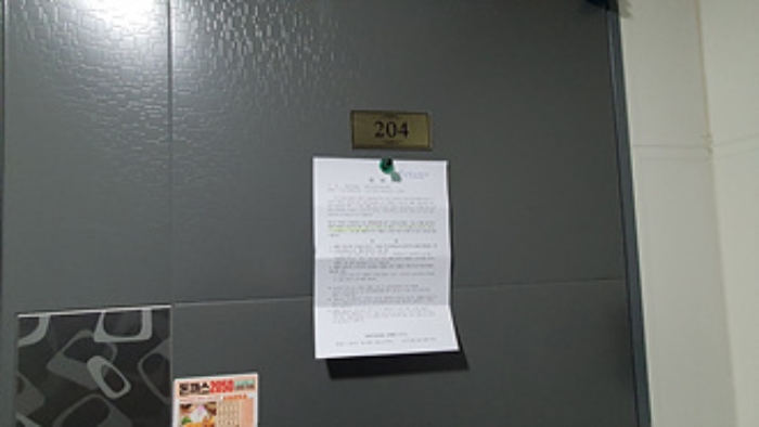204호의 출입문에 부동산경매 사건에 대한 안내문 부착