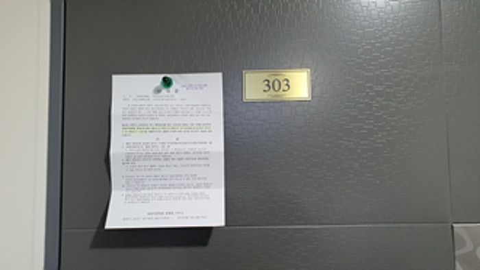 303호의 출입문에 부동산경매 사건에 대한 안내문 부착(1/4)