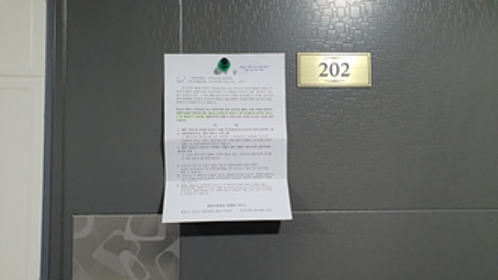 202호의 출입문에 부동산경매 사건에 대한 안내문 부착(1/4)