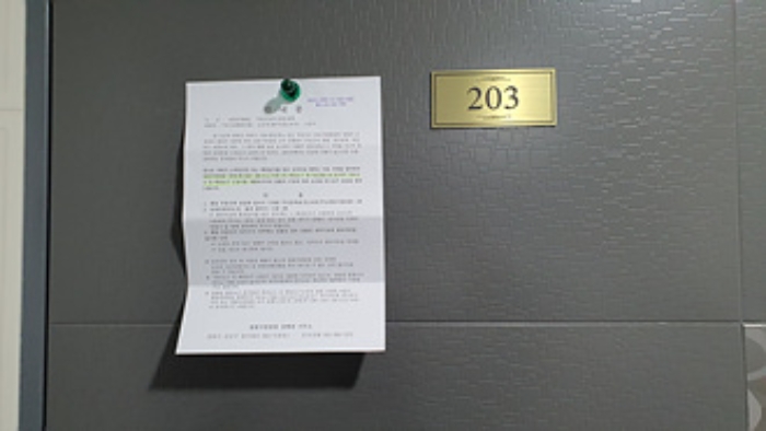 203호의 출입문에 부동산경매 사건에 대한 안내문 부착(1/4)