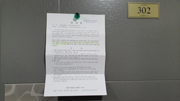 302호의 출입문에 부동산경매 사건에 대한 안내문 부착(1/4)