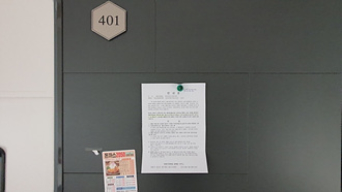 401호의 출입문에 부동산경매 사건에 대한 안내문 부착
