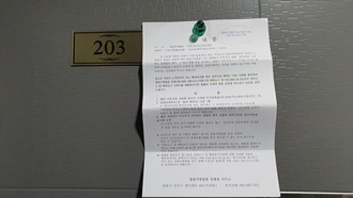 203호의 출입문에 부동산경매 사건에 대한 안내문 부착(1/9)