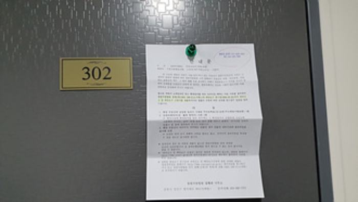 302호의 출입문에 부동산경매 사건에 대한 안내문 부착(1/9)