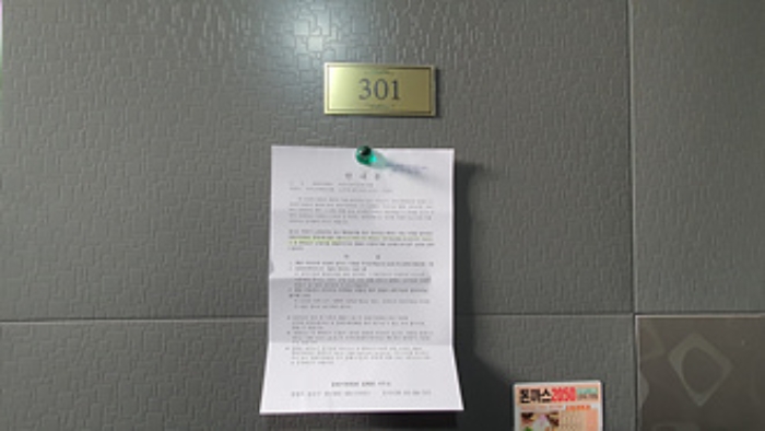 301호의 출입문에 부동산경매 사건에 대한 안내문 부착