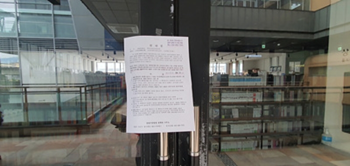 기호 1 출입문에 부동산경매 사건에 대한 안내문 게시