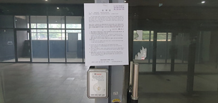 기호 2 출입문에 부동산경매 사건에 대한 안내문 게시