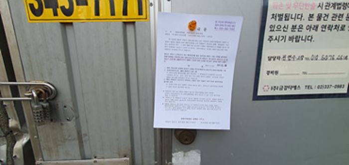 출입문에 부동산경매 사건에 대한 안내문 부착