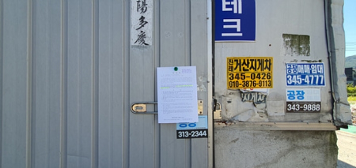 제시 건물-단층공장 A동 출입문에 부동산경매 사건에 대한 안내문 게시