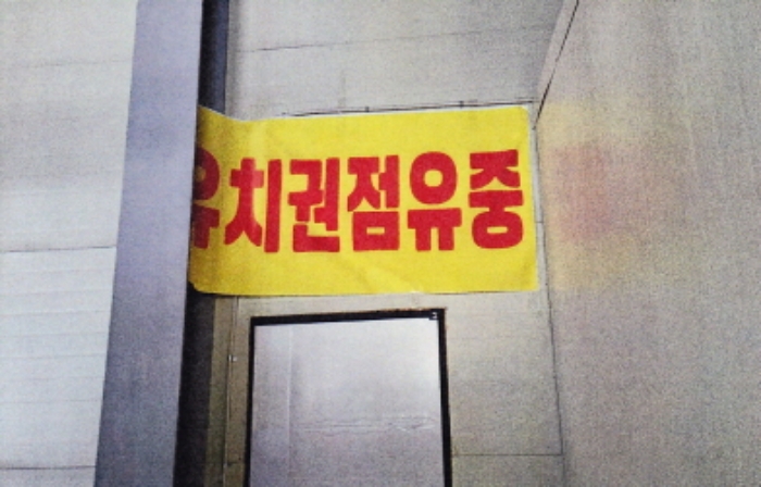 본 건(나동 2층 사무실 출입구에 부착되어 있는 유치권 표시)