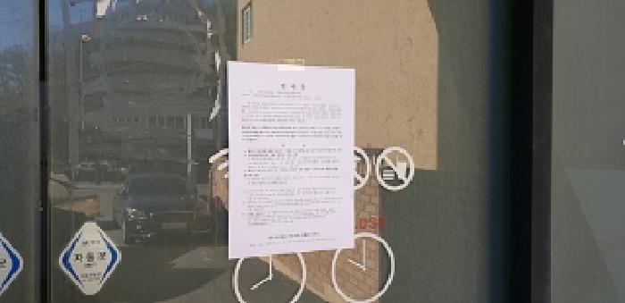 본 부동산 건물 공용출입문 안내문 부착 모습