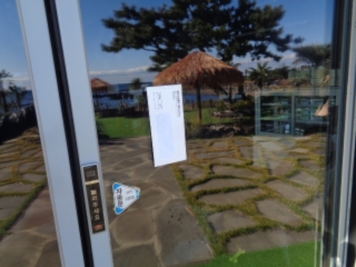 소재지2(난드르로 49-75) 제시건물 출입문 안내문 부착 사진