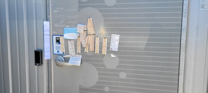 사무실 출입문- 부동산현황조사 안내문 사진 (현재 문이 잠겨있고 장기폐문 상태로 보임)