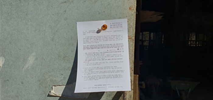 기호 4 제시 건물 입구에 부동산경매 사건에 대한 안내문 게시(12/10)