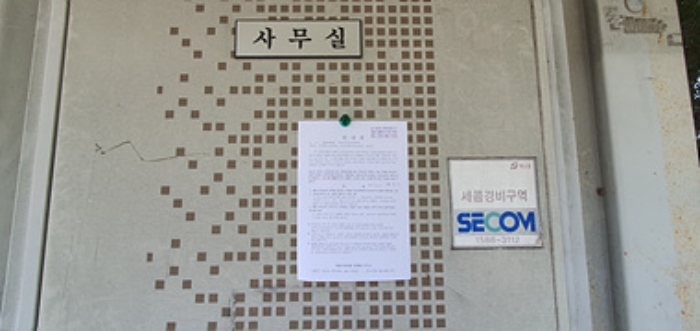 사무실 입구문에 부동산경매 사건에 대한 안내문 부착