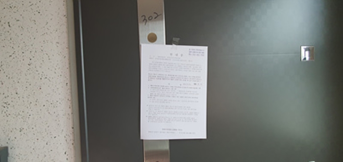 기호 1 제시 건물 302호 출입문에 부동산경매 사건에 대한 안내문 게시