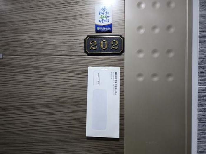 소재지2(하귀5길 18)제시건물 2층(현장표시:202호) 현관 안내문 부착 사진