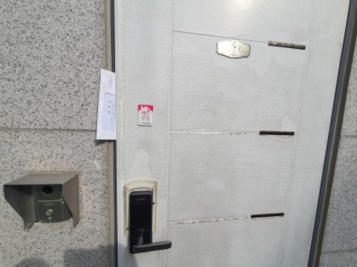 102호 현관문 (문 틈에 안내문을 끼워 둠)