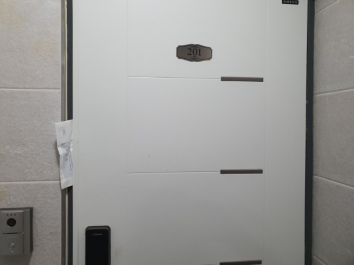 201호 현관문 (문 틈에 안내문을 끼워 둠)