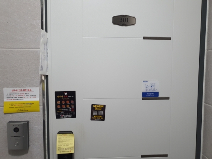 301호 현관문 (문 틈에 안내문을 끼워 둠)