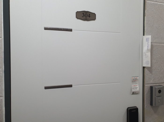 304호 현관문 (문 틈에 안내문을 끼워 둠)
