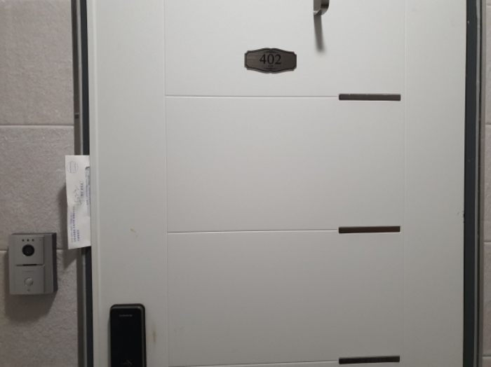 402호 현관문 (문 틈에 안내문을 끼워 둠)