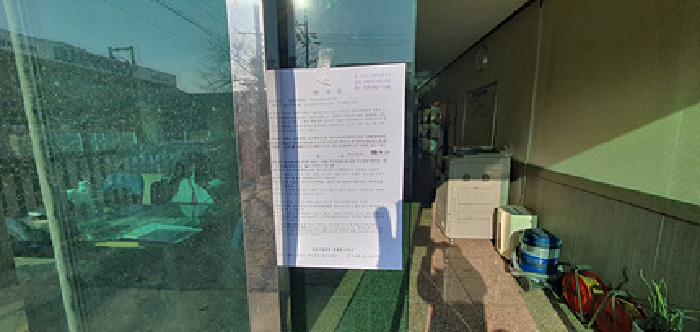 부속1 사무실 1층입구출입문에 부동산경매 사건에 대한 안내문 게시함