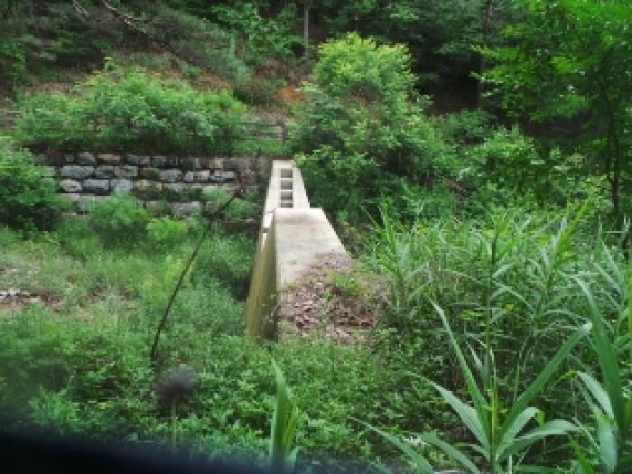 사진26번 [목록번호1번 부동산 일부 지상에 걸쳐 있는 것으로 목측되는 제시외 사방땜 전경] 