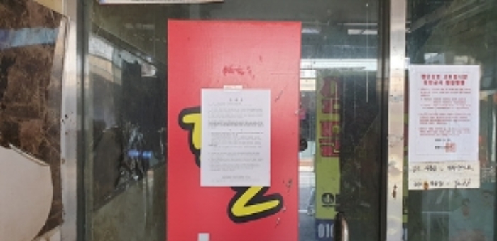 2번 부동산 북측 2층 임차인 이**이 임차사용중인 상가 출입문 안내문 부착모습