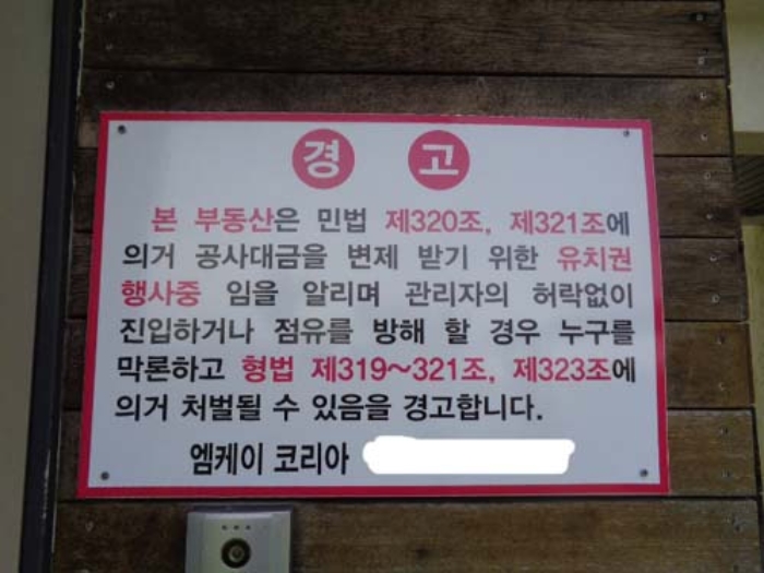 소재지1(107동) 현관 옆 유치권 안내문 사진